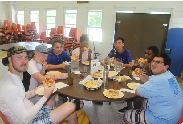 A group of teens eating pizza together