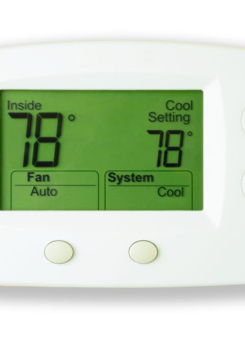 A white digital thermostat with lit display